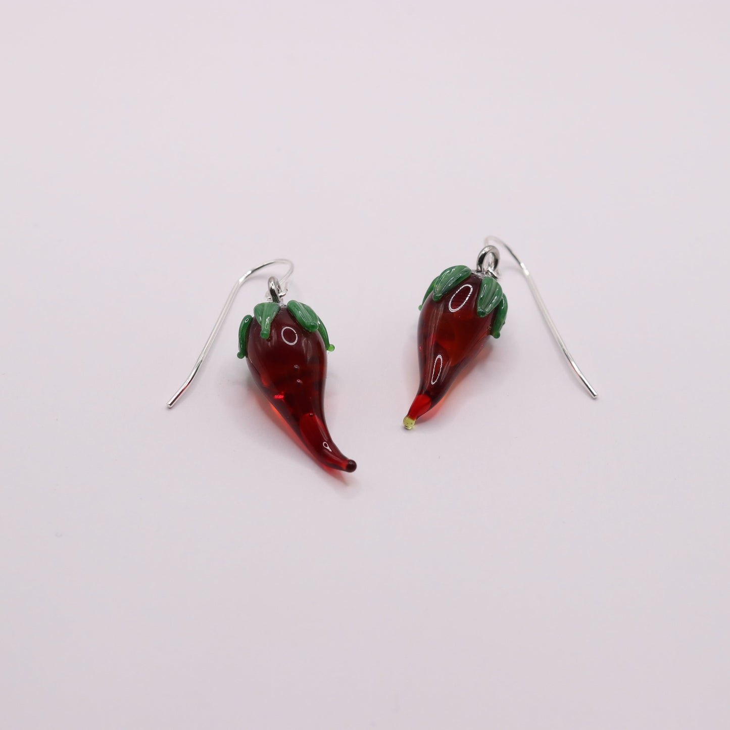 Red chili pepper-shaped earrings on a white background